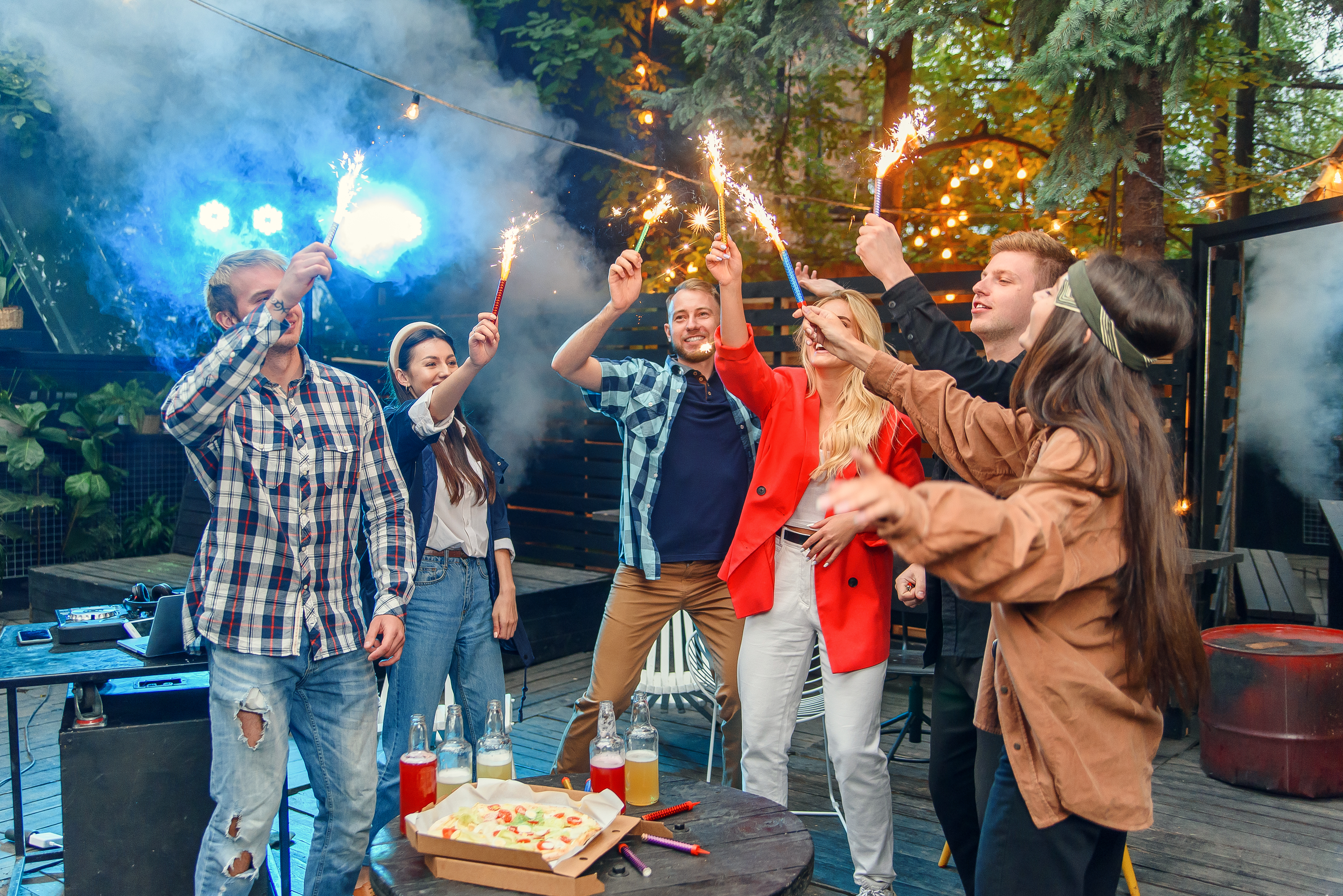group of caucasian friends enjoying fireworks in backyard