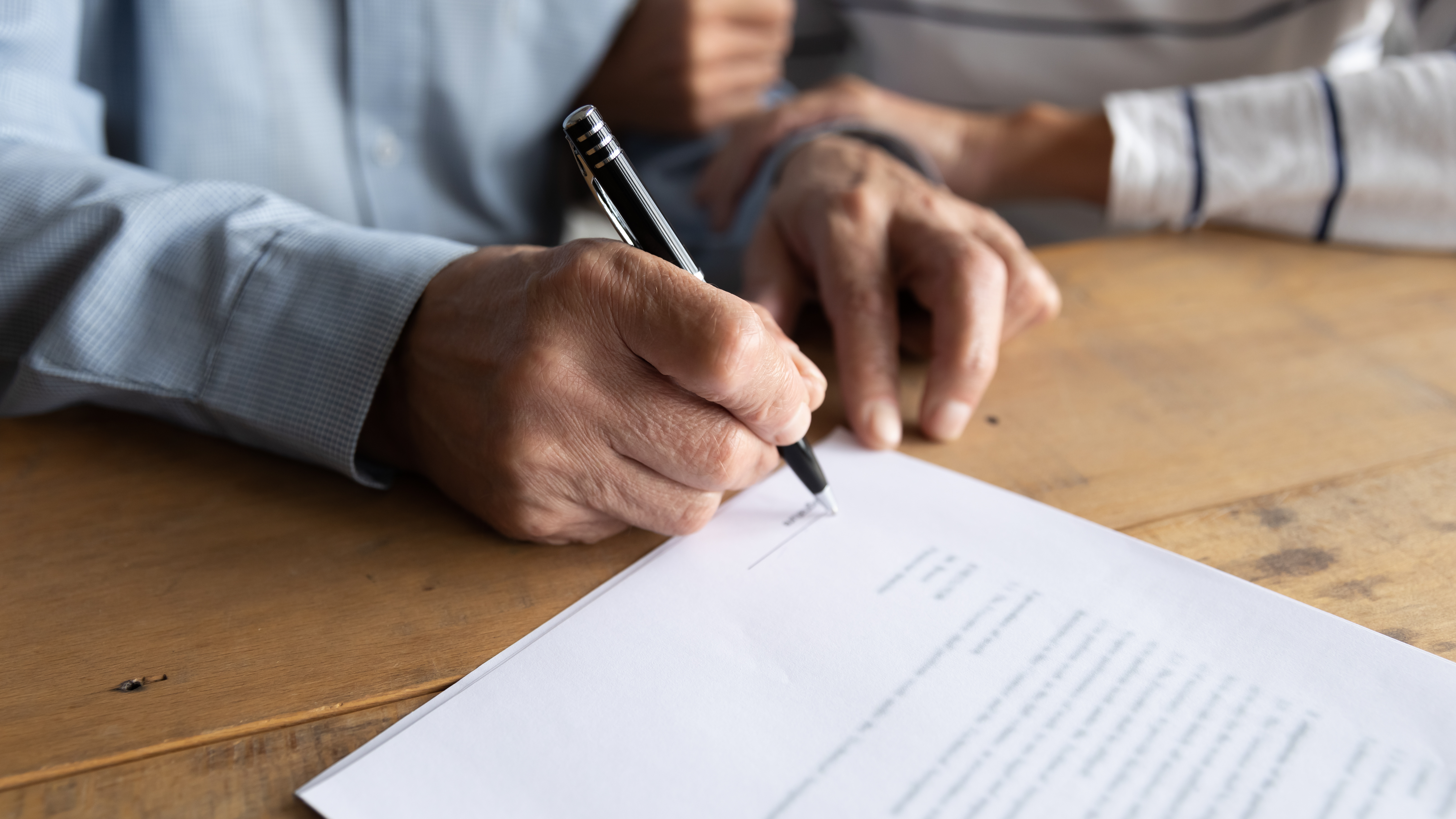 up close of older man signing documents